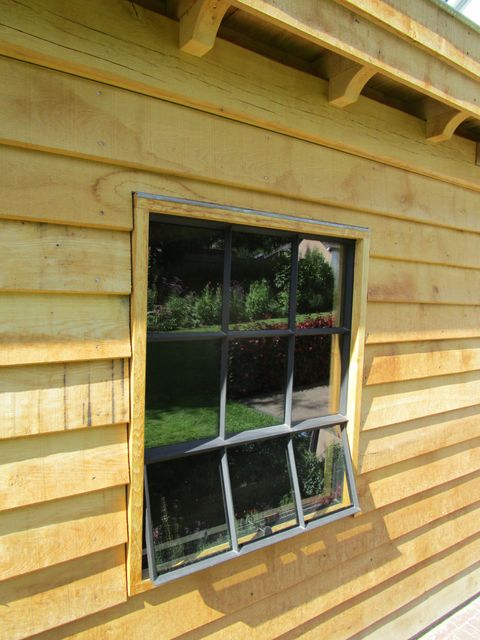 Detail van horizontale houten gevelbekleding rond een raam.