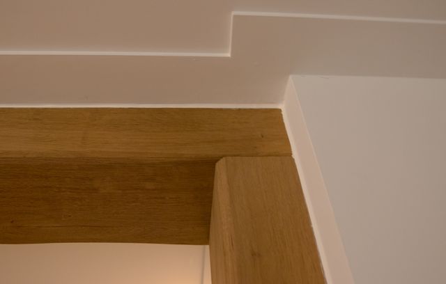 Detail van een aansluiting tussen een horizontale houten balk en een houten staander.